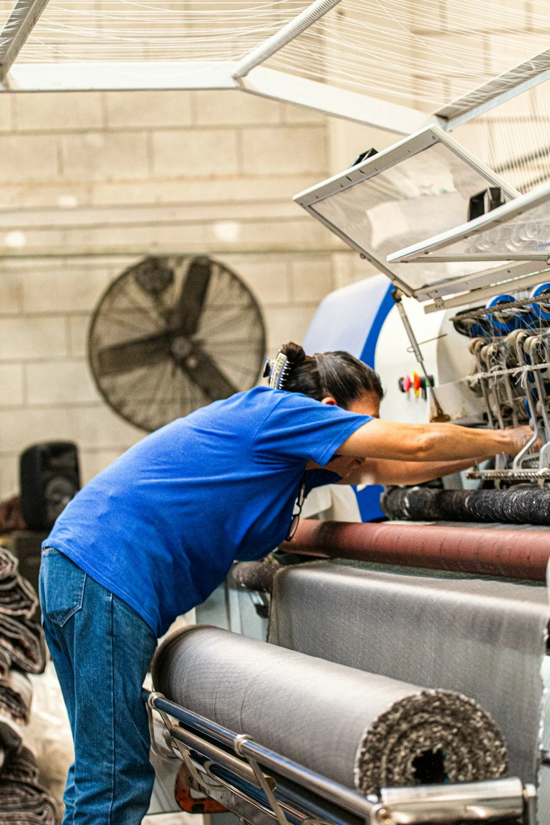 Top view of workers cleaning a large surface with equipment and water hoses.
